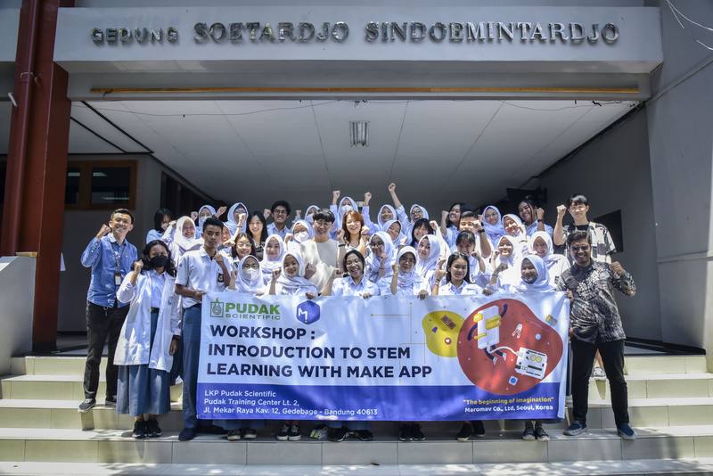 Workshop group with STEM learning banner