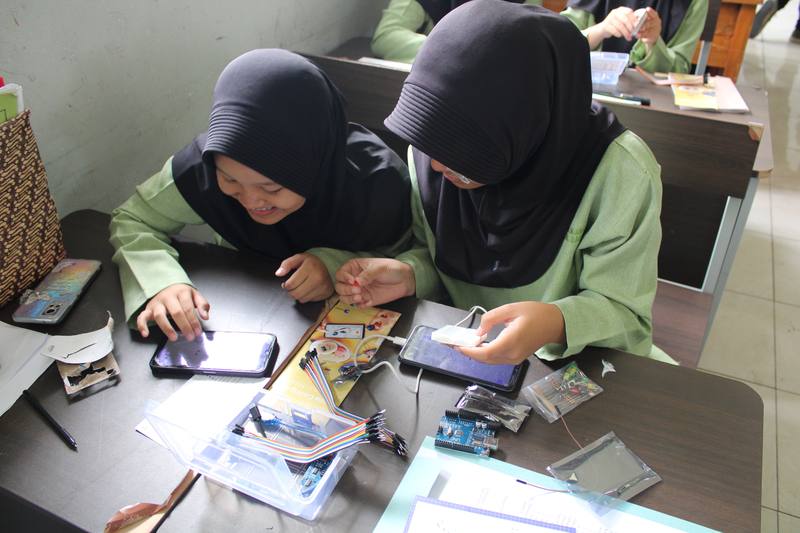 Students with Arduino kit and phones